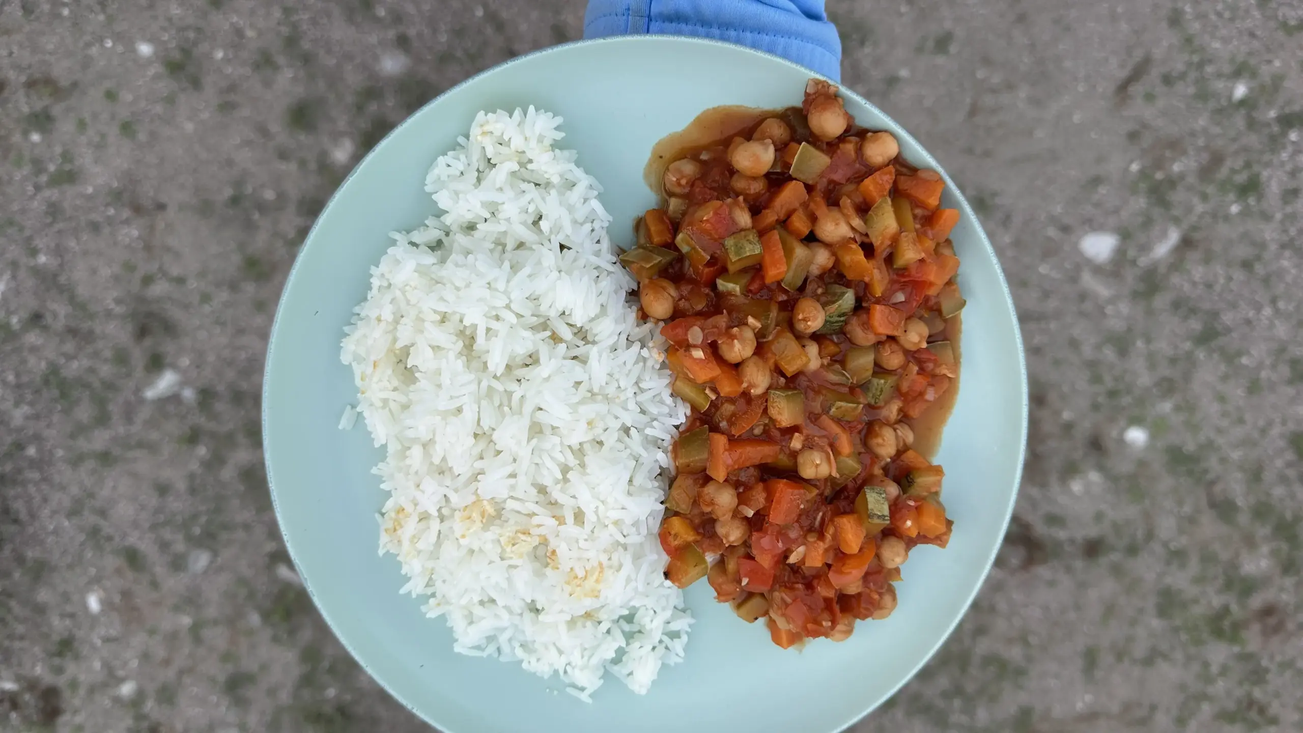 Ein Teller mit dominikanischem Reis mit knuspriger Kruste und Gemüse in Tomatensauce